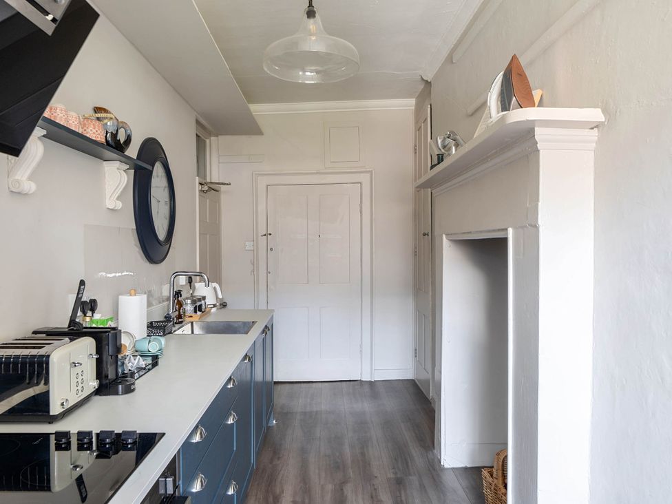 A kitchen with countertop appliances and a clock at Stay Robun in Bath