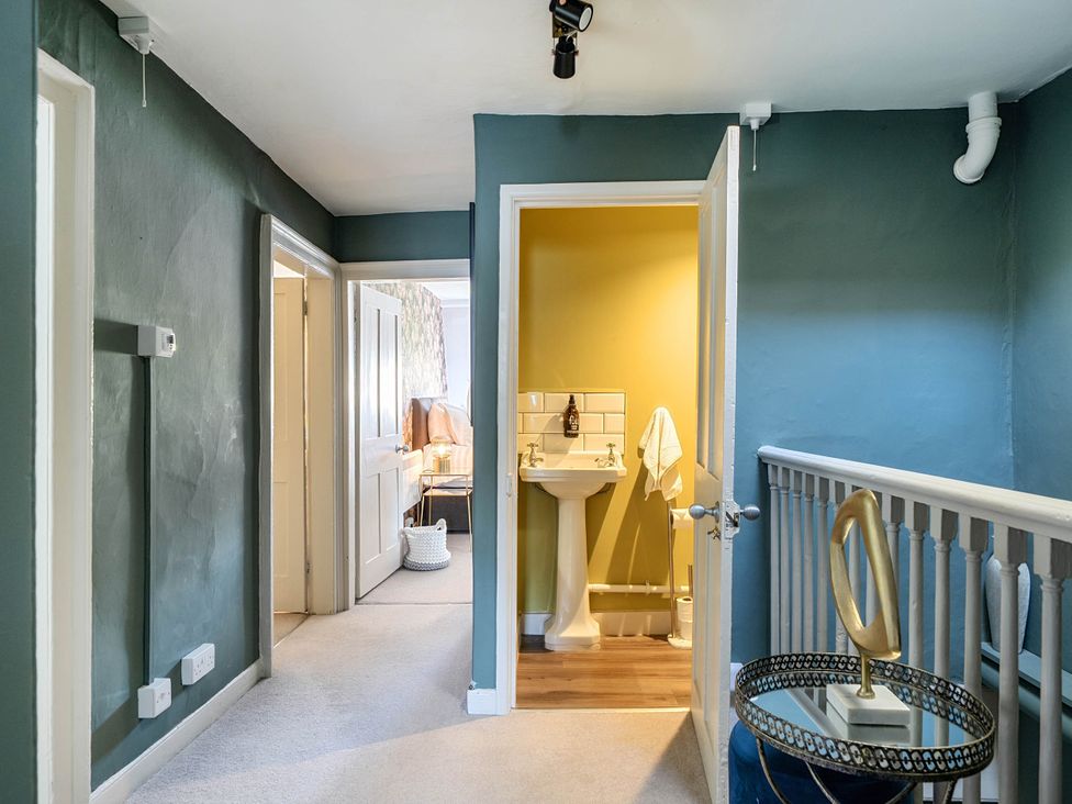 A hallway with a sink and doors at Stay Robun in Bath
