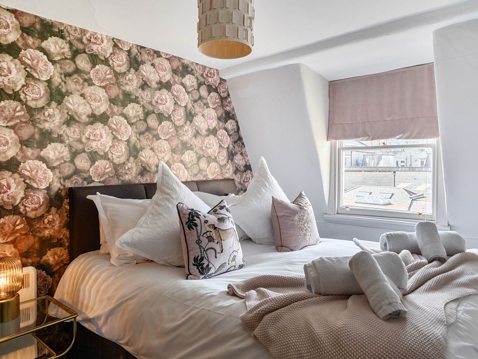 A bedroom with a bed, pillows, and a window at Stay Robun in Bath