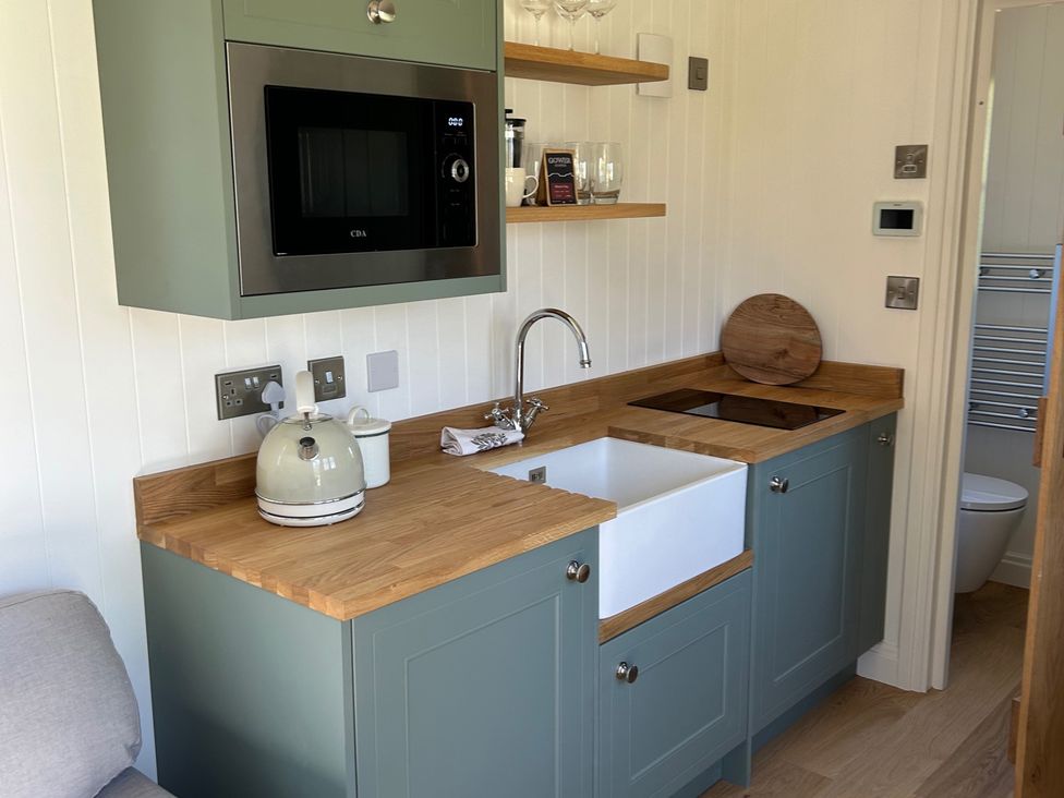 A kitchen with appliances and sink at Y Nyth
