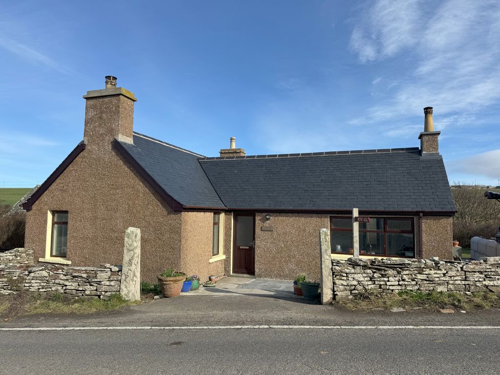 A cottage with a pathway and stone wall at Withi-Gill