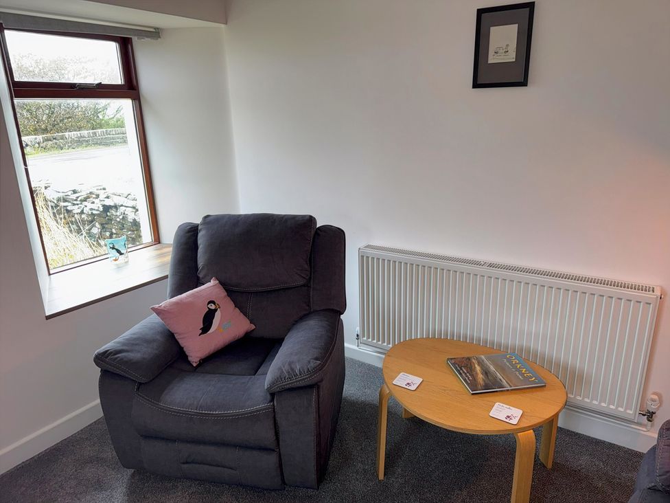 A living room with an armchair and a table at Withi-Gill