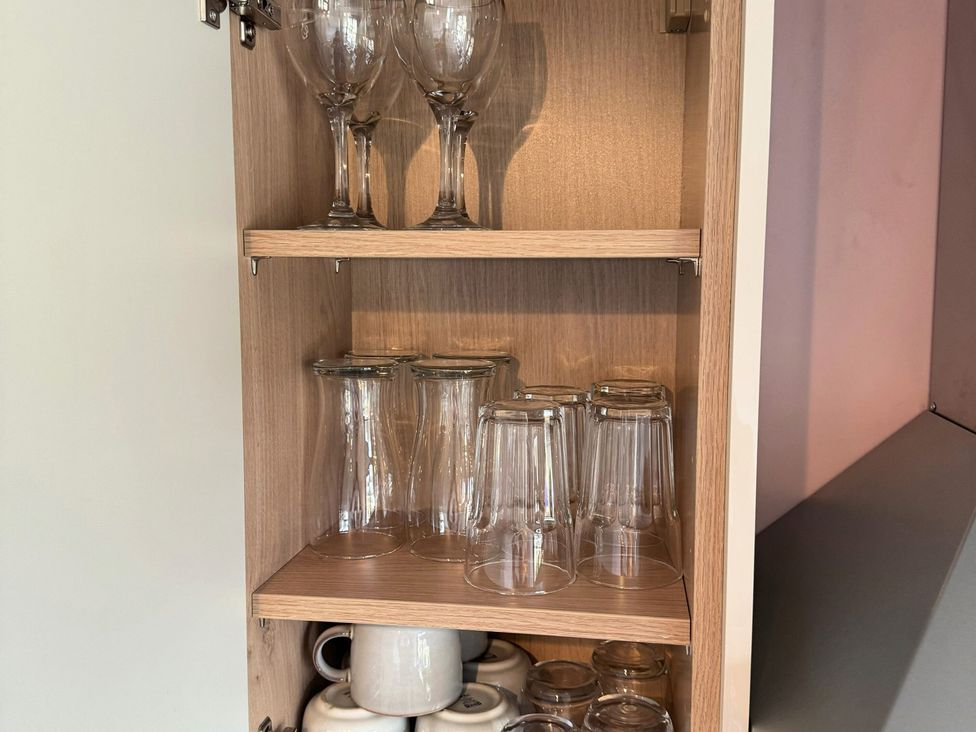 A cabinet with wine glasses and mugs at Withi-Gill