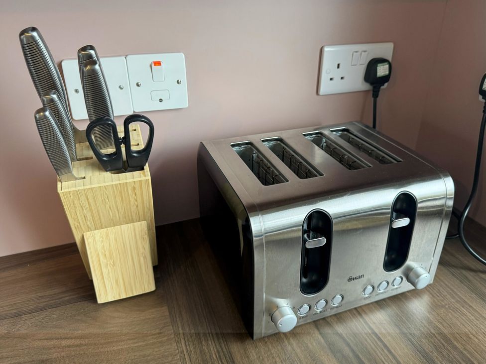 A toaster and knife block with knives and scissors in a kitchen at Withi-Gill 