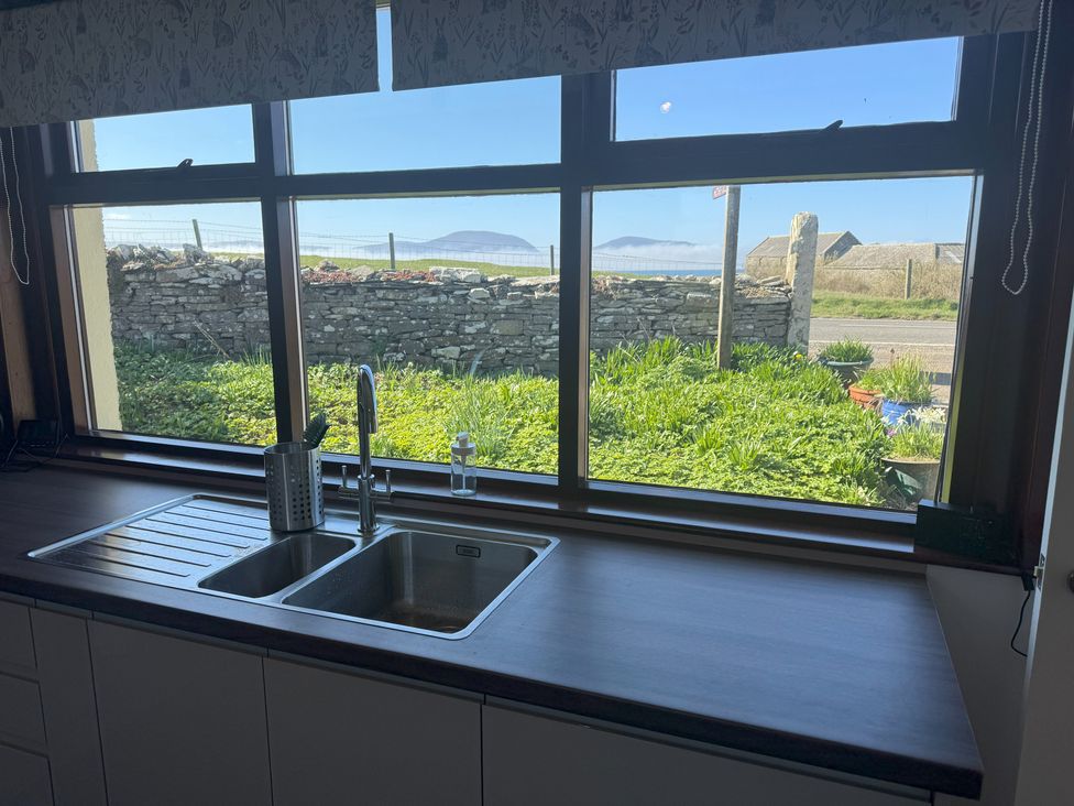 A kitchen with a sink and window showing a garden view at Withi-Gill