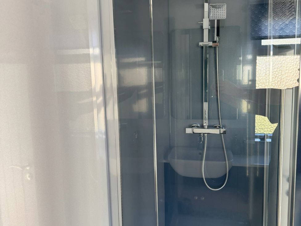 A shower with controls and a sink in a bathroom at Withi-Gill