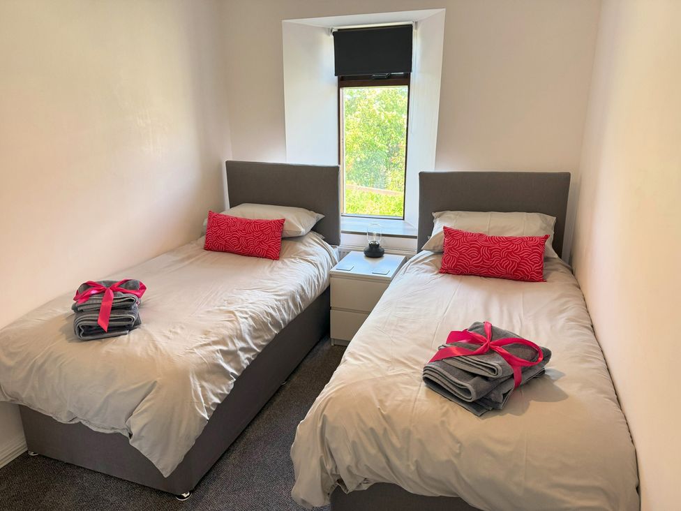 A bedroom with two beds and a window at Withi-Gill