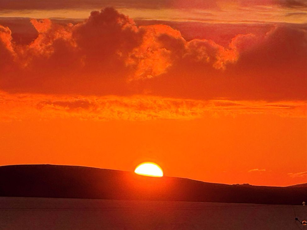 A sunset over the horizon with clouds and water at Withi-Gill 
