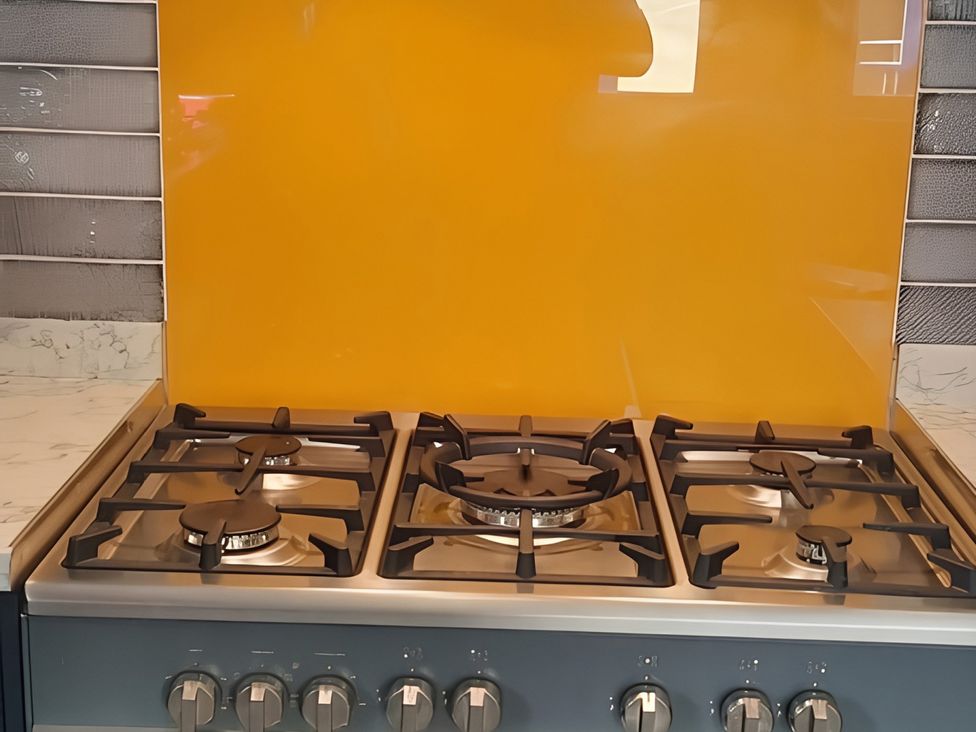 A stove with burners and control knobs at Lil Nauti