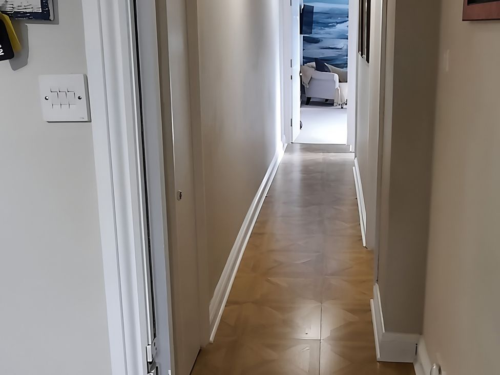 A hallway with light switch and door at Lil Nauti