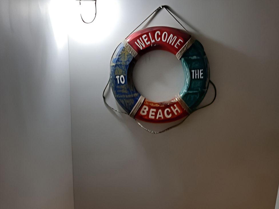 A life ring with the text 'WELCOME TO THE BEACH' on a wall at Lil Nauti