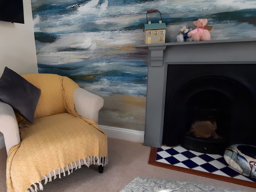 A living room with an armchair and decorative items at Lil Nauti 