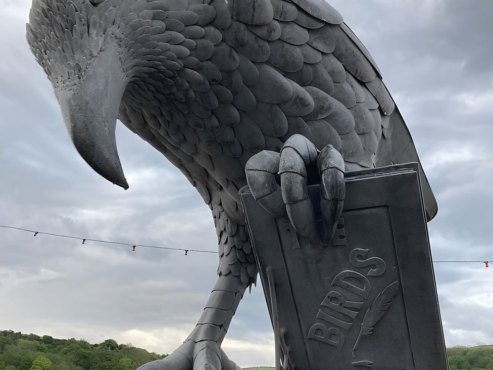 A bird sculpture holding a sign at Lil Nauti