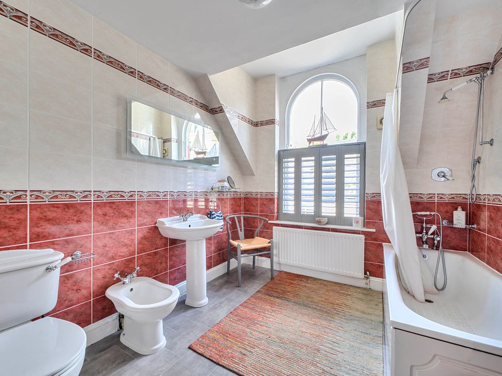A bathroom with a bathtub and sink at Lil Nauti in Fowey