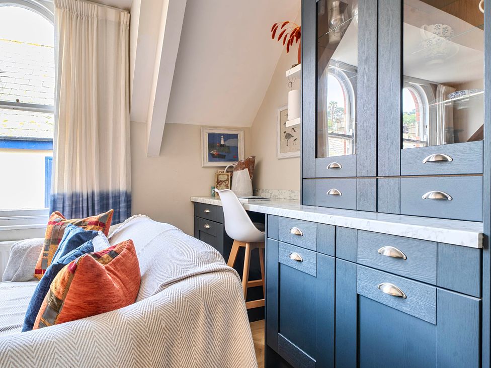A sitting room with a desk and sofa at Lil Nauti Fowey