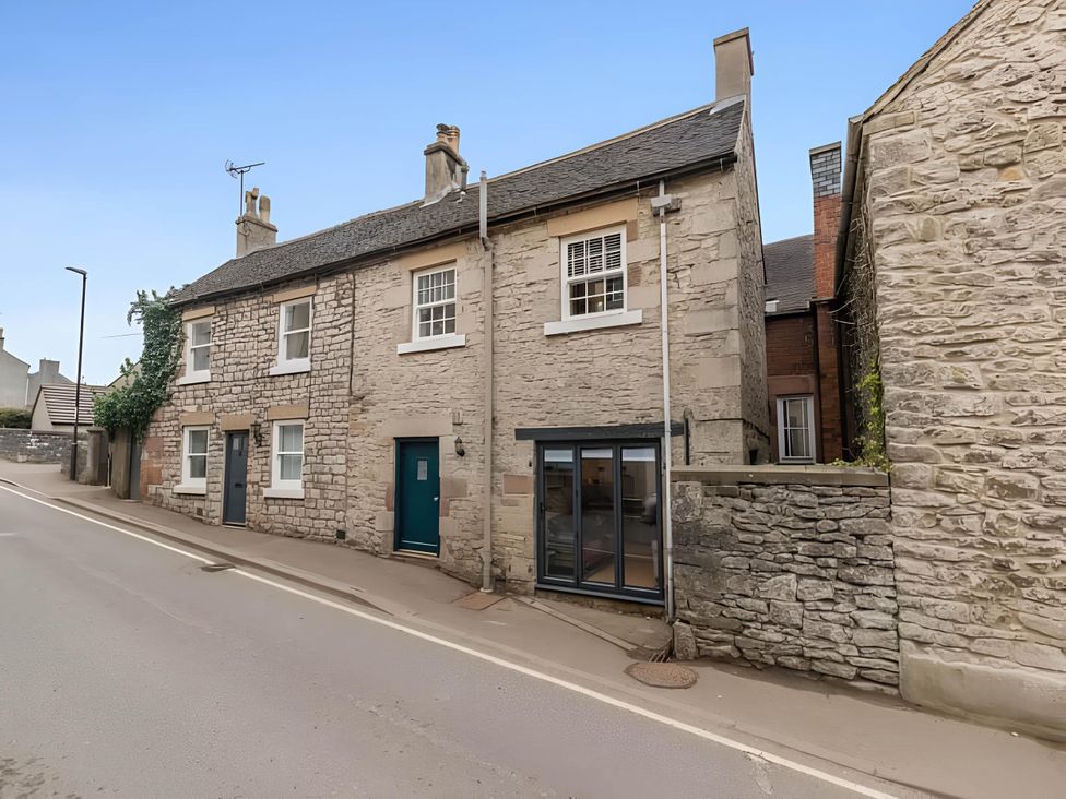 A house with a stone exterior on a street at Belmont Cottage in Matlock