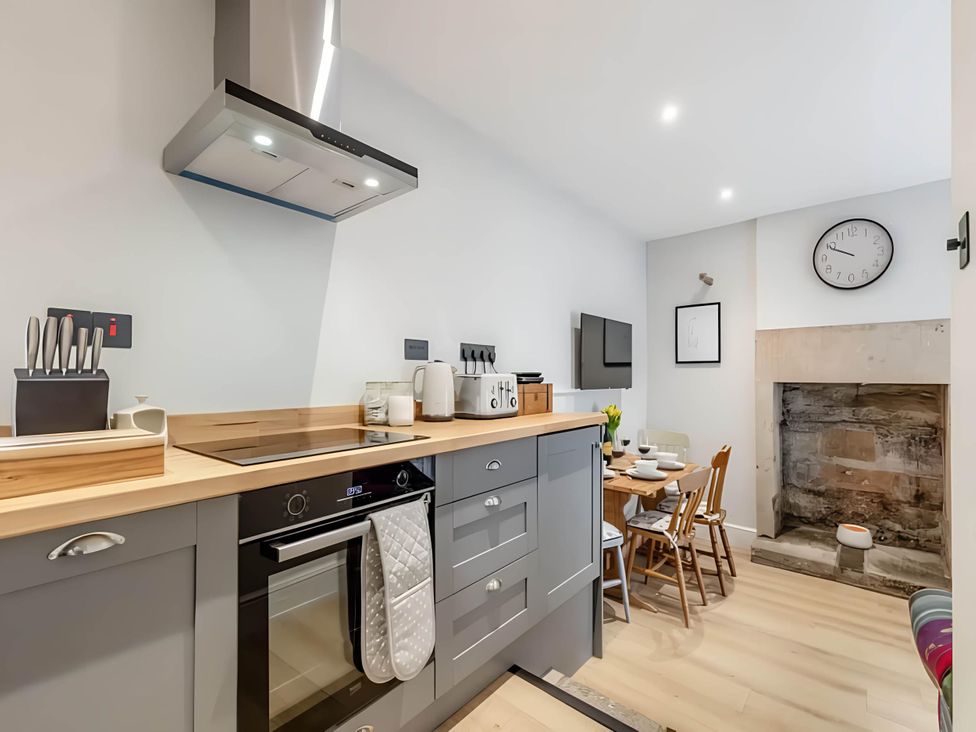 A kitchen with a dining area and appliances at Belmont Cottage in Matlock