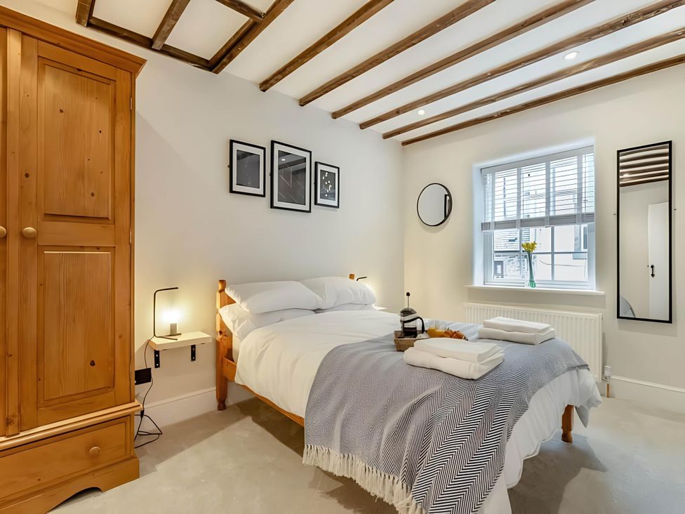 A bedroom with a bed and wardrobe at Belmont Cottage in Matlock