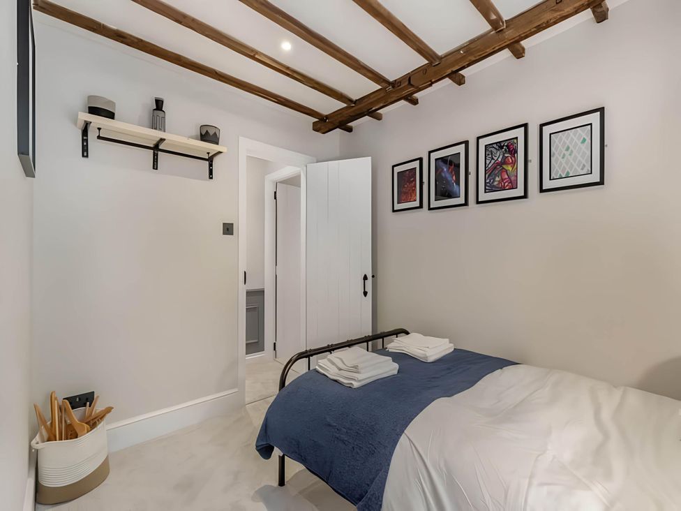 A bedroom with bed and wall art at Belmont Cottage in Matlock