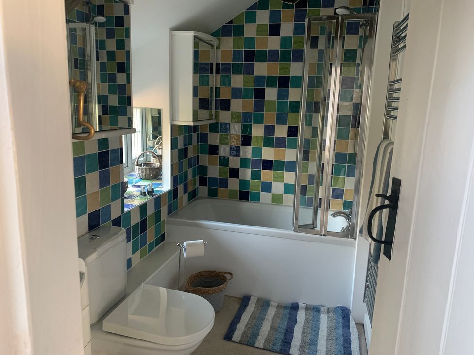 A bathroom with a bathtub and toilet at Bwthyn Nain