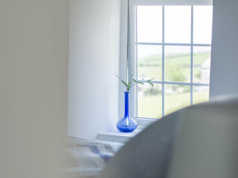 A window with a blue vase and flowers at Bwthyn Nain Harlech