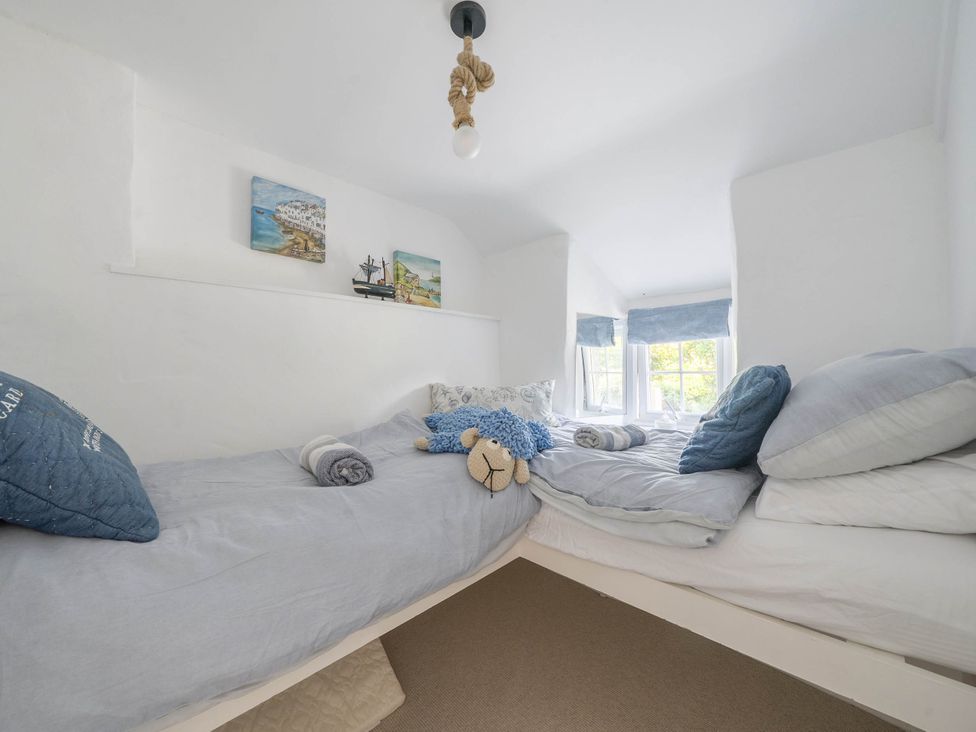 A bedroom with two beds and a decorative wall at Bwthyn Nain in Harlech