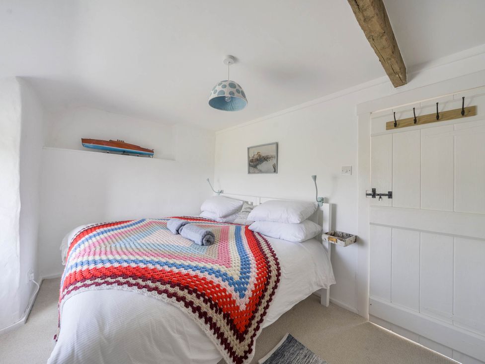 A bedroom with a bed and decorative blanket at Bwthyn Nain in Harlech