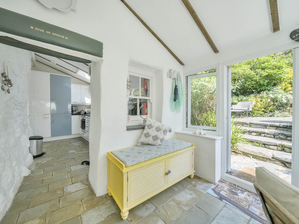 A sunroom with a yellow bench and window at Bwthyn Nain in Harlech
