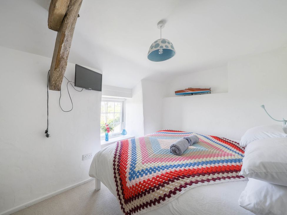 A bedroom with a bed and television at Bwthyn Nain in Harlech