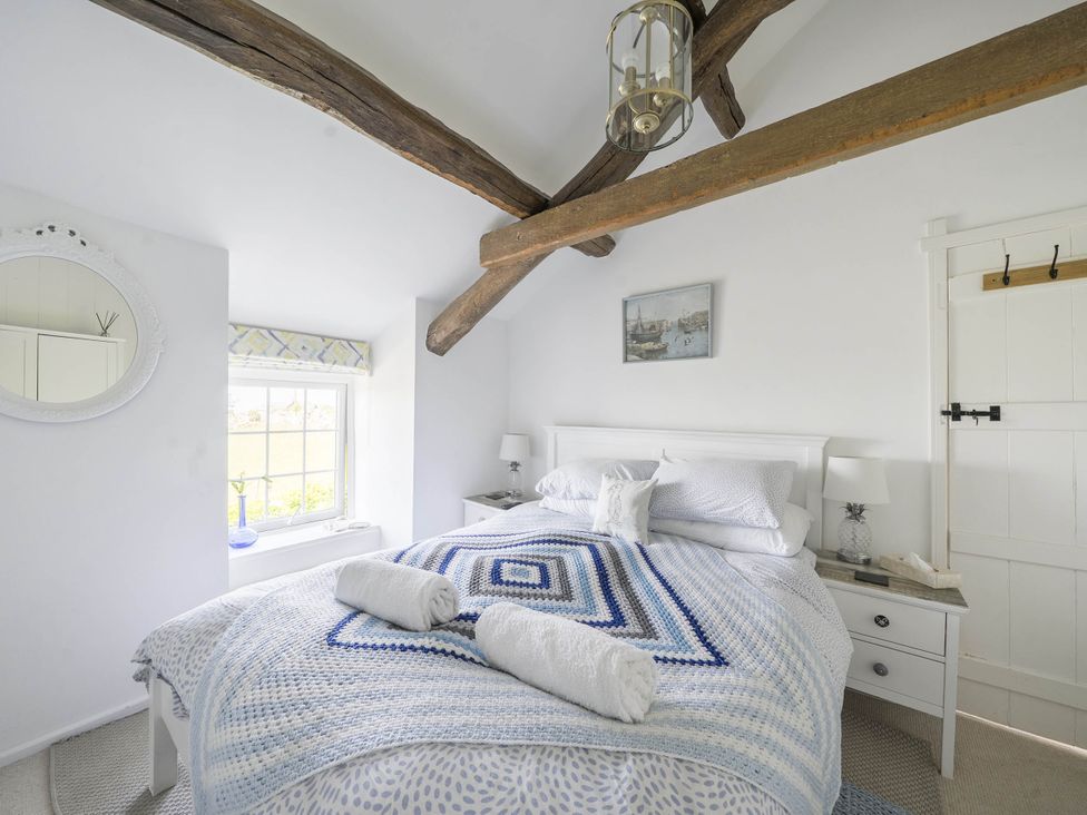 A bedroom with a bed and nightstand at Bwthyn Nain in Harlech