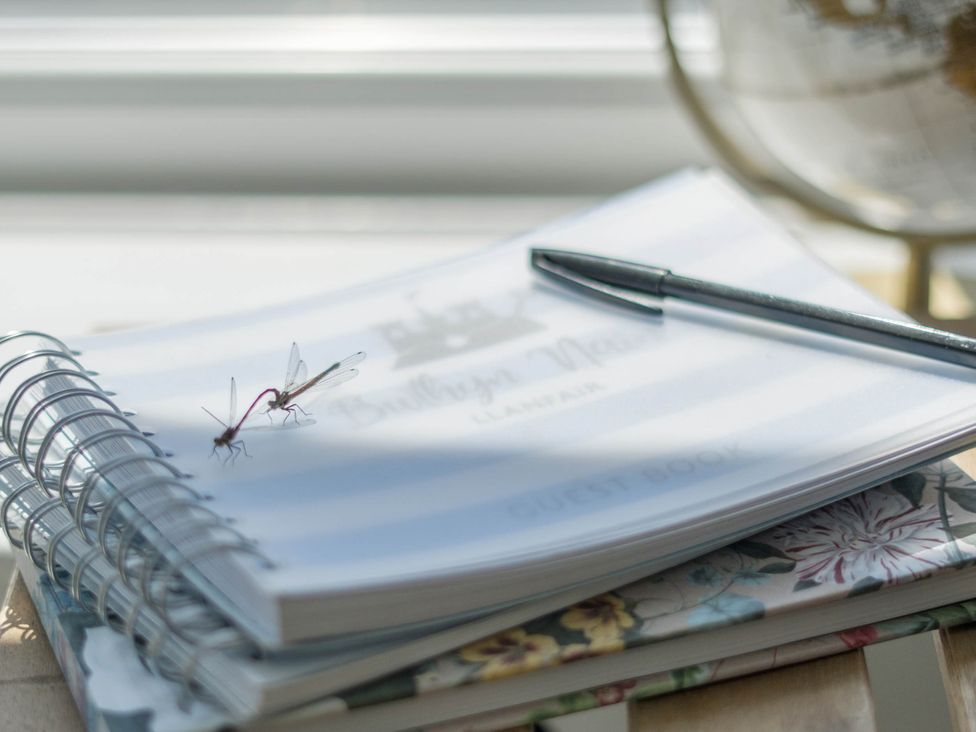 A guest book and pen on a table at Bwthyn Nain in Harlech