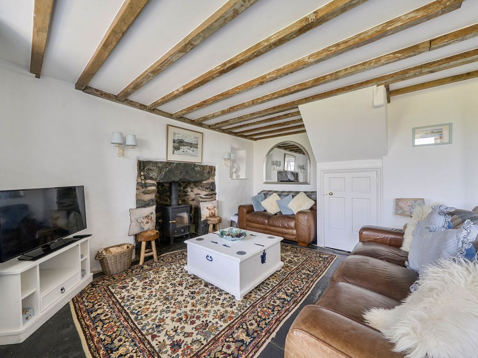 A living room with a fireplace and sofa at Bwthyn Nain in Harlech