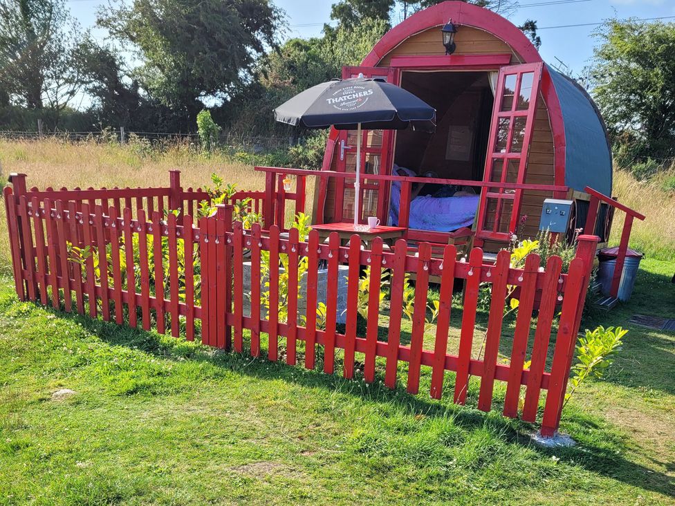 An outdoor glamping pod with a red fence at St Austell Glamping 