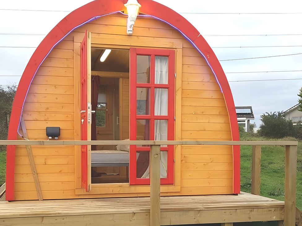 A wooden glamping pod with a deck at St Austell Glamping