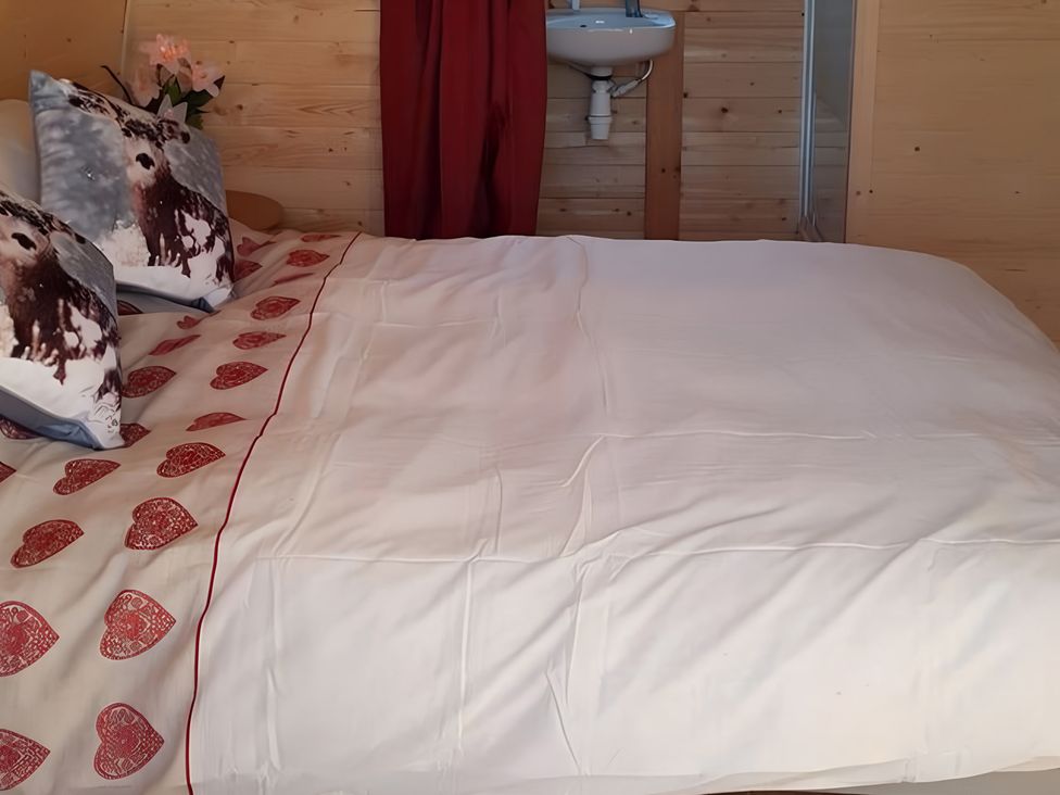 A bedroom with a bed and pillows at St Austell Glamping