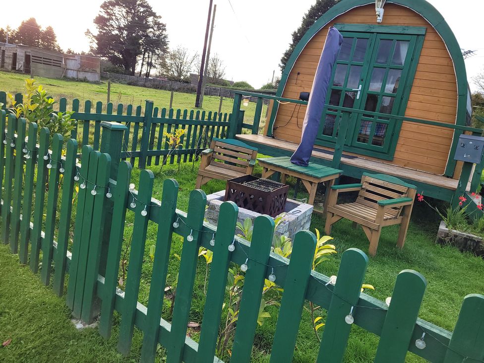 A garden with outdoor furniture and a glamping pod at St Austell Glamping
