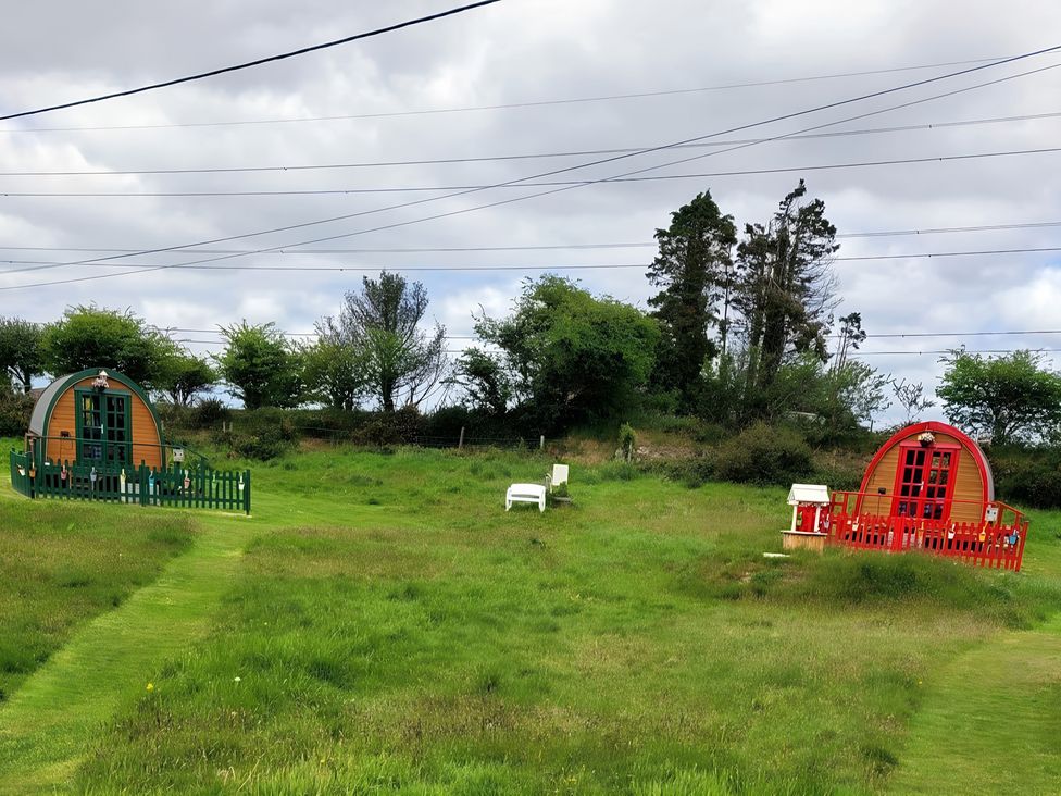 Two cabins in a field with grass at St Austell Glamping