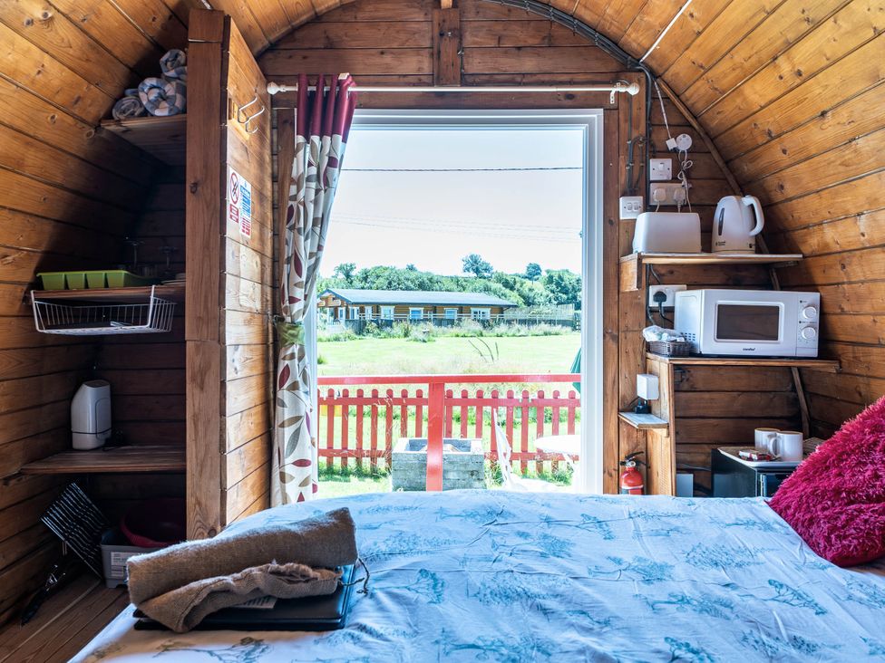 A cabin interior with kitchenette and bed at St Austell Glamping in St Austell