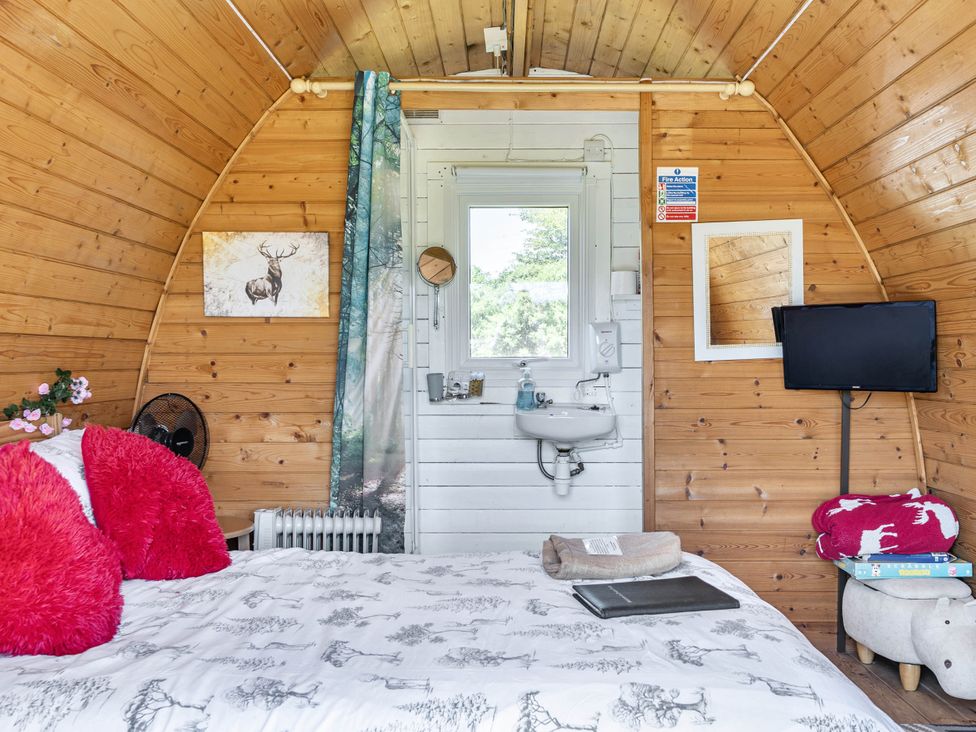 A sleeping area with a bed and sink at St Austell Glamping in St Austell