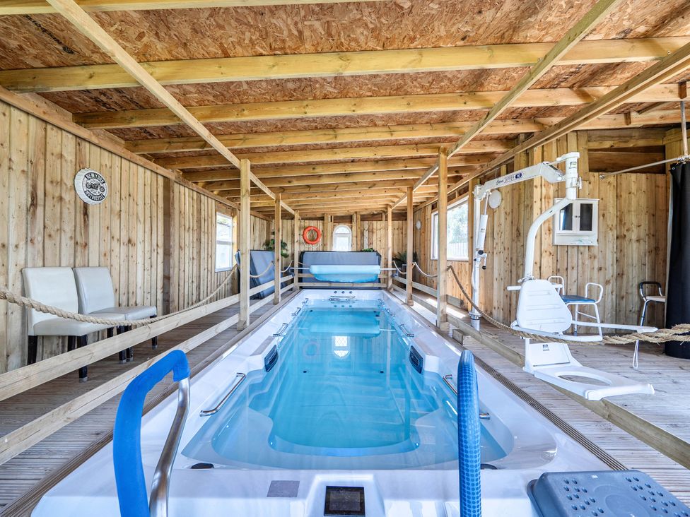 An indoor pool area with a swimming pool and pool lift at St Austell Glamping in St Austell