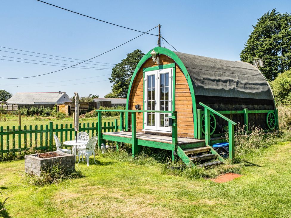 A cabin with a porch and seating area at St Austell Glamping in St Austell