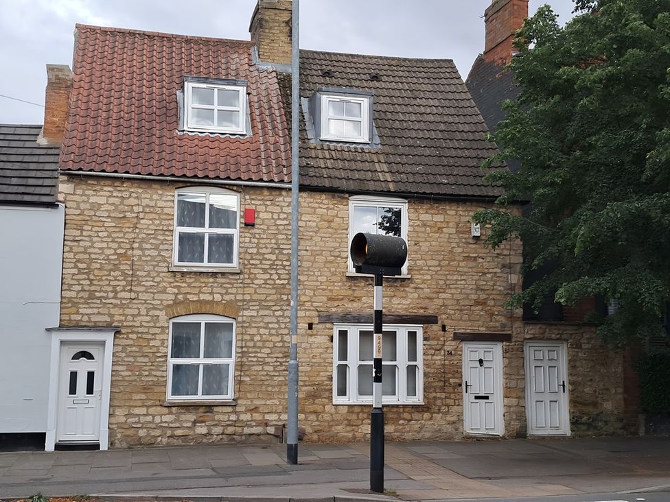 A street view of a house with windows and doors at Charming Lincoln Cottage