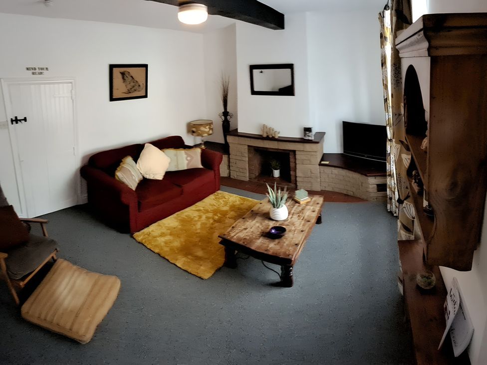 A living room with a sofa and table at Charming Lincoln Cottage