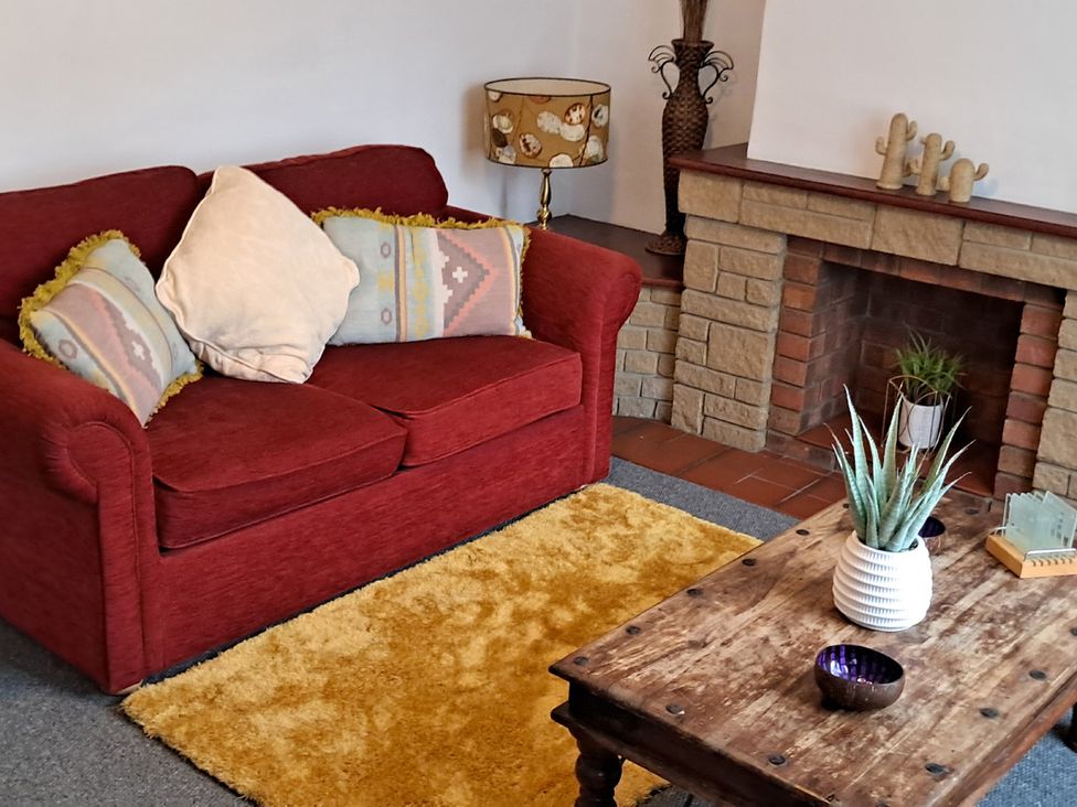A living room with a sofa and coffee table at Charming Lincoln Cottage