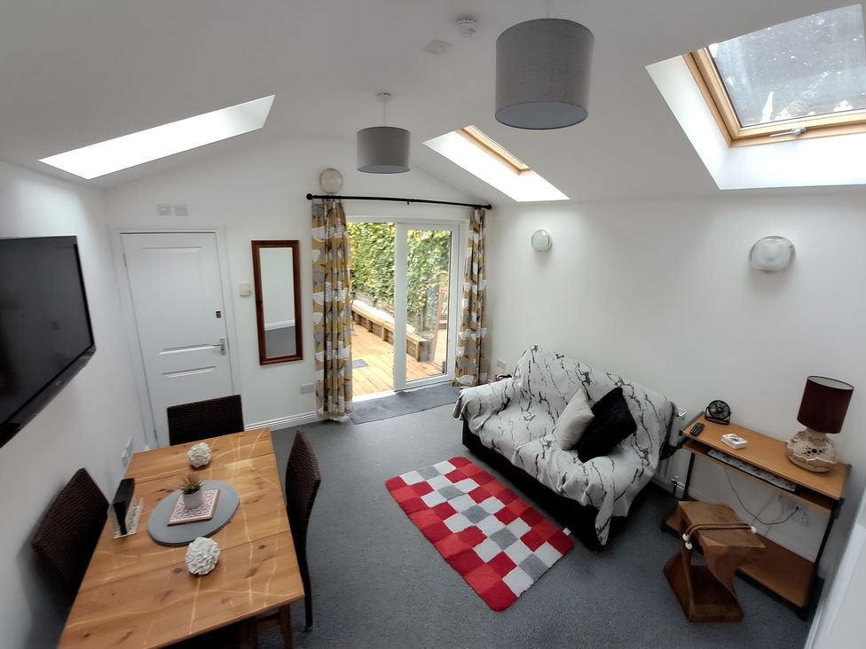 A living room with a sofa and dining table at Charming Lincoln Cottage