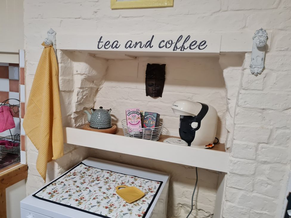 A kitchen shelf with kettle, coffee maker, and tea bags at Charming Lincoln Cottage