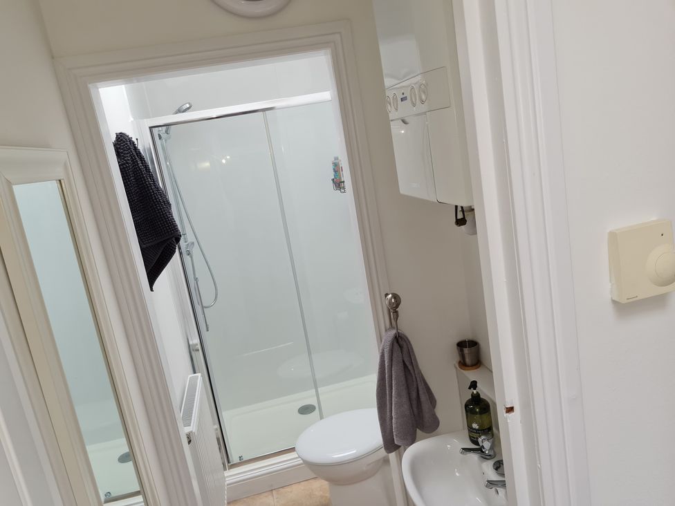 A bathroom with a shower, toilet, and sink at Charming Lincoln Cottage