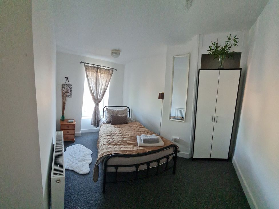 A bedroom with a bed and nightstand at Charming Lincoln Cottage