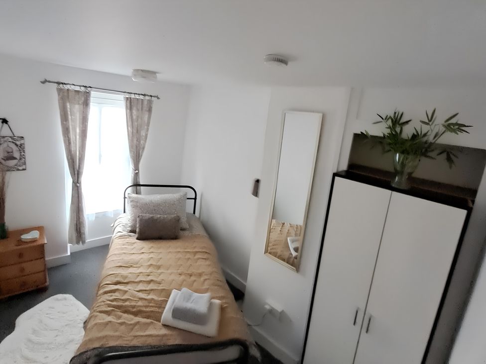 A bedroom with a bed and a wardrobe at Charming Lincoln Cottage