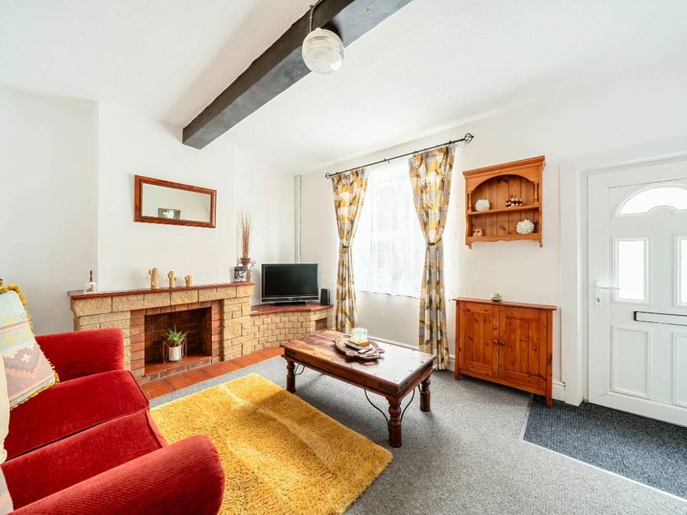 A living room with a coffee table and television at Charming Lincoln Cottage, Lincoln